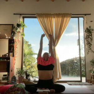 Laura practicando yoga frente a un ventanal con luz natural